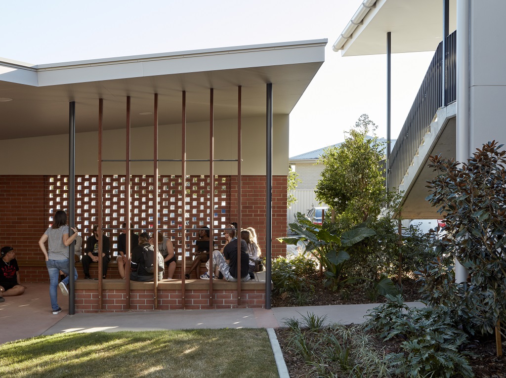 View of the covered ‘outdoor hub’ space, which uses ‘hit and miss’ brickwork to allow light and ventilation in, and includes fixed concrete seating