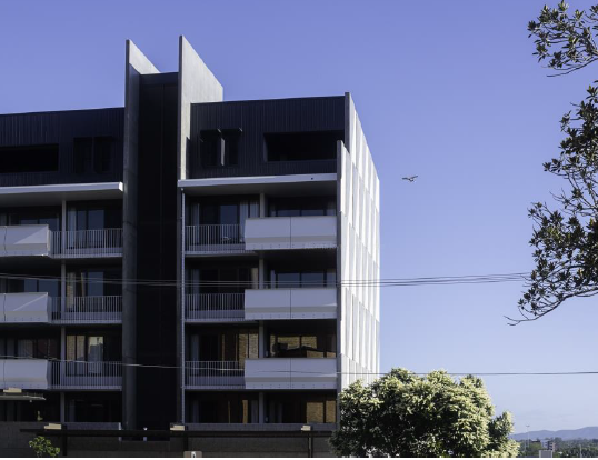 External view of the building, to the sky and mountains beyond. 